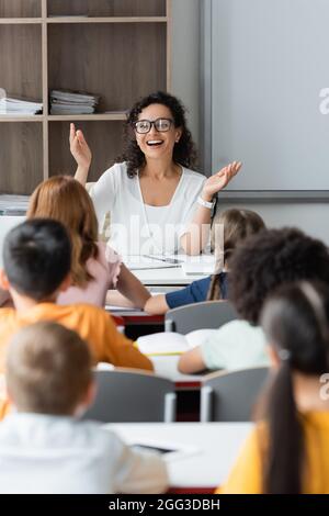 eccitato insegnante afroamericano che mostra il gesto di wow durante la lezione Foto Stock