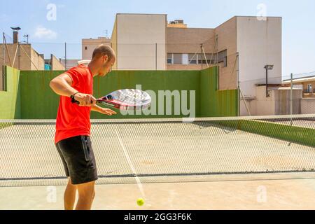 Burriana, Spagna 06-01-2021: Giovane caucasico con abbigliamento sportivo che gioca a paddle tennis Foto Stock