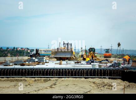 Dnepropetrovsk, Ucraina - 17.08.2021: Costruzione di una nuova tangenziale intorno alla città. Attrezzature da costruzione e lavoratori in loco. Foto Stock