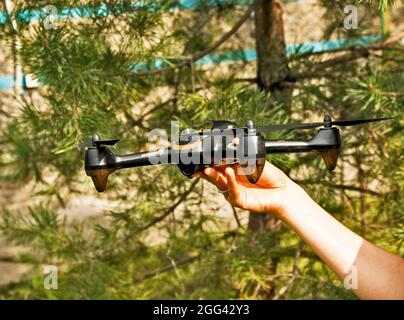 La mano di una donna lancia un drone in volo. Con l'aiuto di un quadricottero, è possibile scattare foto e video. Foto Stock