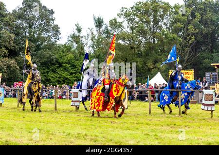 8 agosto 2021 - Cavalieri in armatura che tengono bandiere sui cavalli durante il torneo di jouting al festival medievale Loxwood Joust, West Sussex, Inghilterra, Regno Unito Foto Stock