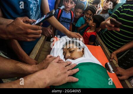 Gaza, Palestina. 28 agosto 2021. (NOTA DEI REDATTORI: L'immagine raffigura la morte) i palestinesi pianggono vicino al corpo di un Omar Abu al-Nilo di 12 anni nella parte orientale della città di Gaza. Abu al-Nile è morto di ferite che ha sostenuto durante una protesta contro la recinzione di confine tra Israele e Gaza il 21 agosto 2021. I disordini hanno lasciato 42 manifestanti feriti e cecchino israeliano è stato anche sparato e in una condizione critica. Credit: SOPA Images Limited/Alamy Live News Foto Stock