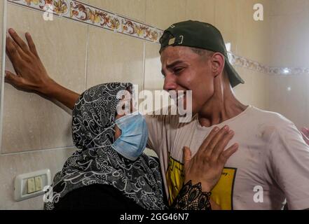 Gaza, Palestina. 28 agosto 2021. I parenti di un Omar palestinese di 12 anni Abu al-Nil piangono durante la sua processione funebre nella parte orientale di Gaza. Abu al-Nile è morto di ferite che ha sostenuto durante una protesta contro la recinzione di confine tra Israele e Gaza il 21 agosto 2021. I disordini hanno lasciato 42 manifestanti feriti e cecchino israeliano è stato anche sparato e in una condizione critica. Credit: SOPA Images Limited/Alamy Live News Foto Stock