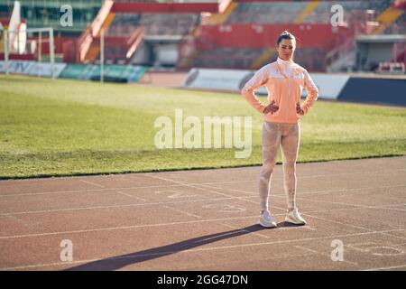 Runner professionale è in pista.pareggiatore donna sorridente in abbigliamento sportivo. Foto Stock