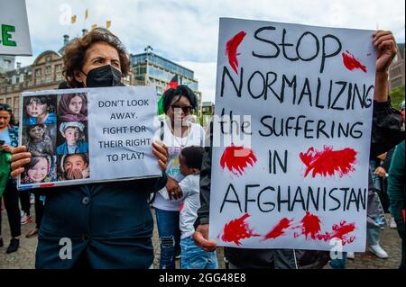 Amsterdam, Paesi Bassi. 28 agosto 2021. Durante la manifestazione, i manifestanti hanno appurato dei cartelli.migliaia di persone si sono riunite nel centro di Amsterdam per dimostrare il loro sostegno al popolo afghano intrappolato a Kabul sotto il regime dei talebani e per esortare il governo olandese a dichiarare l'Afghanistan un paese di origine non sicuro, in modo che i rifugiati afghani e le persone afghane non siano documentate può avere il diritto legale di asilo e sicurezza. Credit: SOPA Images Limited/Alamy Live News Foto Stock