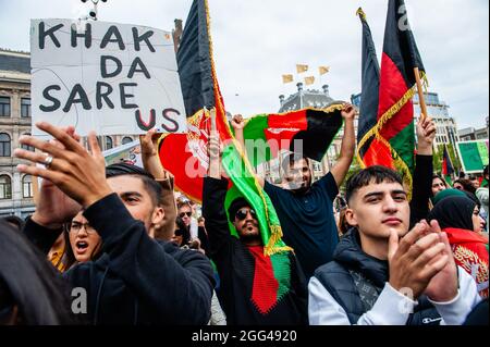 Amsterdam, Paesi Bassi. 28 agosto 2021. Durante la manifestazione, i manifestanti detengono bandiere afghane.migliaia di persone si sono radunate nel centro di Amsterdam per dimostrare il loro sostegno al popolo afghano intrappolato a Kabul sotto il regime talebano e per esortare il governo olandese a dichiarare l'Afghanistan un paese di origine non sicuro, in modo che i rifugiati afghani e afghani non siano documentati i cittadini possono avere il diritto legale di asilo e di sicurezza. (Foto di Ana Fernandez/SOPA Images/Sipa USA) Credit: Sipa USA/Alamy Live News Foto Stock