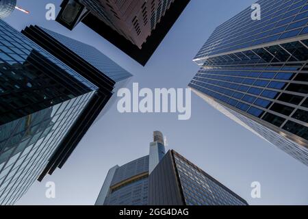 Basso angolo di vista tra i moderni grattacieli, alto edificio nel quartiere centrale di Francoforte, Germania contro il cielo blu. Foto Stock