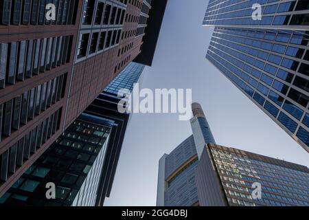 Basso angolo di vista tra i moderni grattacieli, alto edificio nel quartiere centrale di Francoforte, Germania contro il cielo blu. Foto Stock