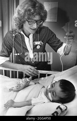 Austin Texas USA, circa 1990: L'infermiera controlla il bambino nell'ospedale dei bambini, Austin. NESSUN ID per nessun rilascio Foto Stock