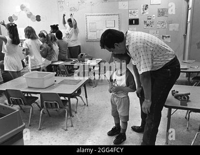 Austin Texas USA, circa 1995: Papà che scende dal bambino al centro privato di assistenza diurna. ©Bob Daemmrich Foto Stock