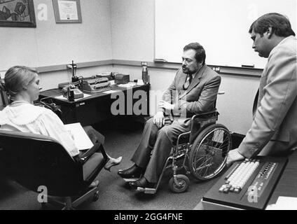 Austin Texas USA, circa 1990: Programmatore informatico IBM legalmente cieco in sedia a rotelle collabora con i colleghi al nuovo progetto. ©Bob Daemmrich Foto Stock