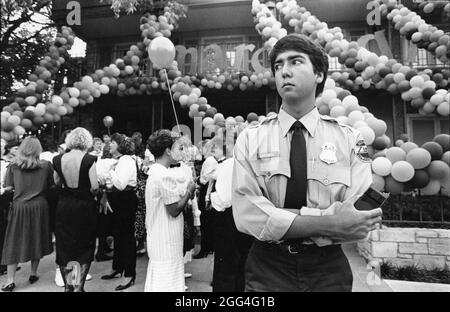 Austin Texas USA, circa 1992: Giovane guardia di sicurezza maschile privato guarda sopra la festa di sorpresenza all'Università del Texas ad Austin. Foto Stock