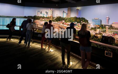 Toronto, Canada. 28 agosto 2021. La gente guarda 'Little Niagara Area' durante la mostra Little Canada a Toronto, Canada, il 28 agosto 2021. Con diverse aree a tema geografico, l'immersiva mostra Little Canada ha offerto ai visitatori una vista dall'alto del Canada, con gli edifici in scala 1:87 qui da questo agosto. Credit: Zou Zheng/Xinhua/Alamy Live News Foto Stock