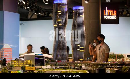 Toronto, Canada. 28 agosto 2021. La gente guarda 'Little Toronto Area' durante la mostra Little Canada a Toronto, Canada, il 28 agosto 2021. Con diverse aree a tema geografico, l'immersiva mostra Little Canada ha offerto ai visitatori una vista dall'alto del Canada, con gli edifici in scala 1:87 qui da questo agosto. Credit: Zou Zheng/Xinhua/Alamy Live News Foto Stock