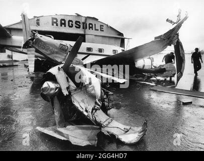 Austin Texas USA, 1987: I lavoratori guardano l'aereo danneggiato dopo il tornado un piccolo aeroporto privato colpito. ©Bob Daemmrich Foto Stock