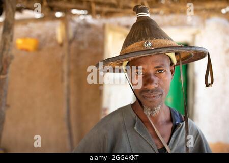 Uomo di mezza età che indossa un tradizionale cappello Fulani in fibra conica nella regione di Ségou, Mali, Africa occidentale. Foto Stock