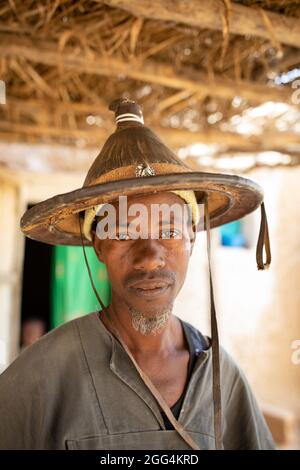 Uomo di mezza età che indossa un tradizionale cappello Fulani in fibra conica nella regione di Ségou, Mali, Africa occidentale. Foto Stock