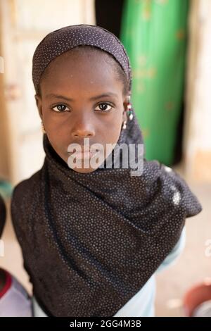 Djeneba Barry (10) proviene da una famiglia di allevatori di bestiame Fulani tradizionali che soffrono regolarmente la fame. Lei e i suoi fratelli non hanno mai frequentato la scuola e probabilmente non lo faranno mai. Foto Stock