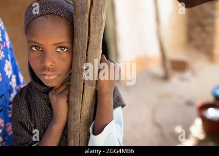 Djeneba Barry (10) proviene da una famiglia di allevatori di bestiame Fulani tradizionali che soffrono regolarmente la fame. Lei e i suoi fratelli non hanno mai frequentato la scuola e probabilmente non lo faranno mai. Foto Stock