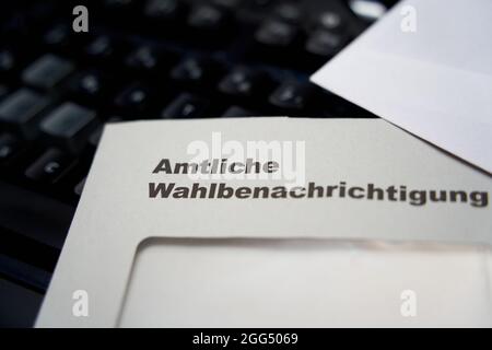 Lettere nere su busta bianca: Notifica ufficiale delle elezioni (in tedesco: Amtliche Wahlbenachrichtigung). Tastiera nera sullo sfondo. Profondità di Foto Stock