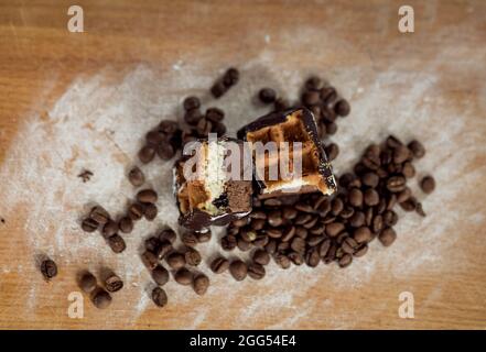 Torta al caffè. Cialde di cioccolato in chicchi di caffè decorati. Cibo dolce. Dolce dessert. Sfondo in legno. Foto Stock