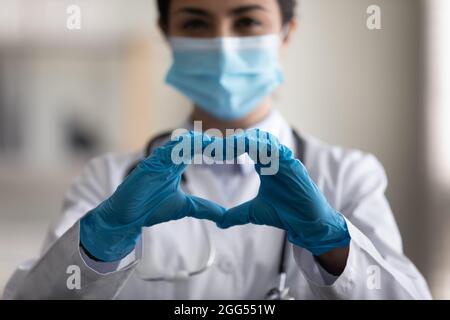 Primo piano medico indiano millenario che mostra simbolo d'amore. Foto Stock