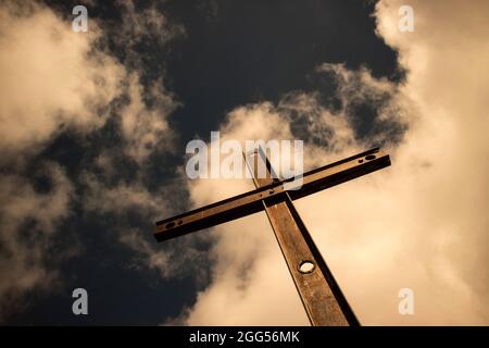 Il simbolo di ferro della religione cattolica visto nel cielo nuvoloso Foto Stock