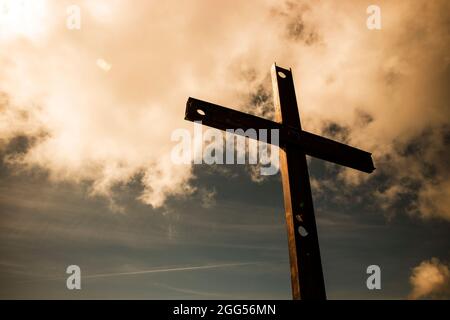 Il simbolo di ferro della religione cattolica visto nel cielo nuvoloso Foto Stock