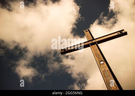 Il simbolo di ferro della religione cattolica visto nel cielo nuvoloso Foto Stock