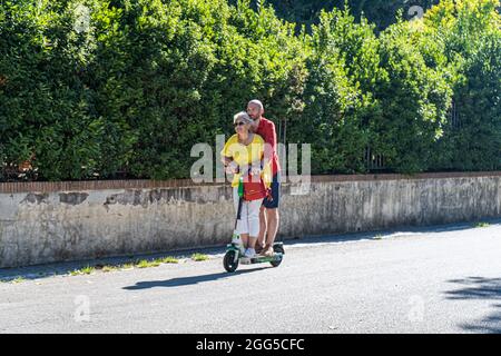 ROMA ITALIA, REGNO UNITO. 29 agosto 2021. Un uomo e una donna che cavalcano insieme a Villa Borghese su uno scooter elettrico Lime in una giornata calda a Roma. Gli scooter elettrici sono diventati popolari nella capitale romana e vengono utilizzati regolarmente come mezzi di trasporto per la mobilità. Credit: amer Ghazzal/Alamy Live News Foto Stock