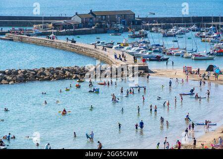 Lyme Regis, Dorset, Regno Unito. 29 agosto 2021. UK Meteo: I turisti e le famiglie si affollano alla spiaggia popolare presso la stazione balneare di Lyme Regis per assorbire il sole caldo e il cielo blu limpido durante il fine settimana di vacanza in banca. Con il glorioso tempo soleggiato impostato per continuare in Bank Holiday Lunedi, le spiagge e resort lungo la costa meridionale sono attesi per essere ancora più imballate del solito, come più persone godono di staycations nel Regno Unito questa estate. Il credito: Celia McMahon/Alamy Live News Foto Stock