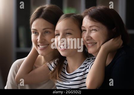 Felice piccola ragazza coccolare mummia e nonna. Foto Stock