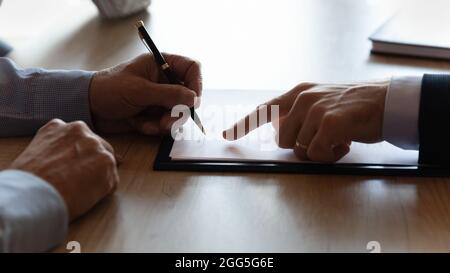 Primo piano tagliato di uomo maturo firma contratto, tenendo penna Foto Stock