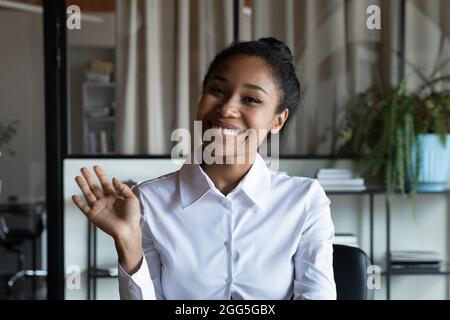Testa ritratto sorridente donna d'affari afroamericana che agita la mano Foto Stock
