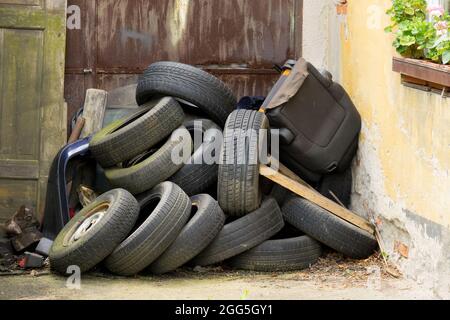 Scartato usato, vecchi pneumatici di gomma alla porta della casa Foto Stock