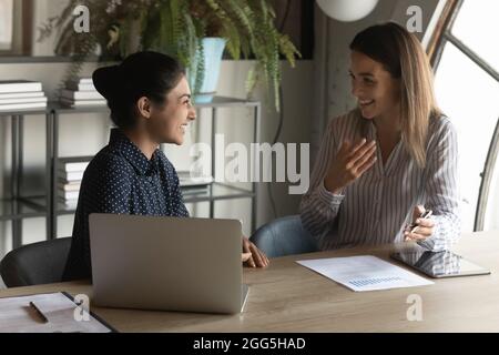 Sorridendo colleghi diversi amici che parlano, divertirsi in ufficio Foto Stock