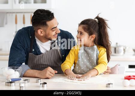 Carino ragazza araba cottura in cucina con il suo papà Foto Stock