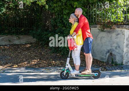 ROMA ITALIA, REGNO UNITO. 29 agosto 2021. Un uomo e una donna che cavalcano insieme a Villa Borghese su uno scooter elettrico Lime in una giornata calda a Roma. Gli scooter elettrici sono diventati popolari nella capitale romana e vengono utilizzati regolarmente come mezzi di trasporto per la mobilità. Credit: amer Ghazzal/Alamy Live News Foto Stock