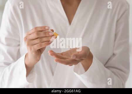 Primo piano giovane donna in accappatoio applicazione siero. Foto Stock