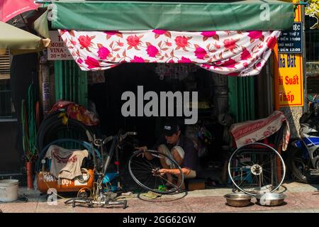 HO chi MINH, VIETNAM - 11 maggio 2018: Una vista esterna di un uomo che fissa una bicicletta a ho Chi Minh City, Vietnam Foto Stock