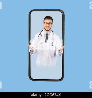Maschio medico sullo schermo dello smartphone parlare con la fotocamera, sfondo blu Foto Stock