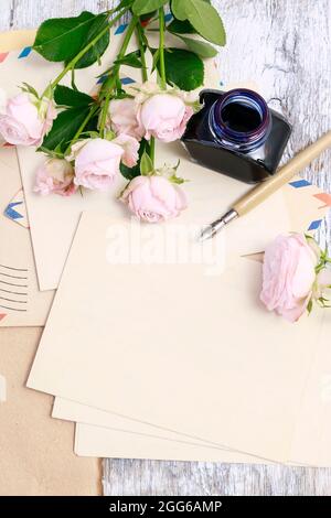 Cancelleria vintage e fiori rosa rosa intorno, spazio copia. Foto Stock