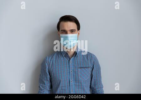 Ritratto di uomo millenario indossare maschera medica sul viso Foto Stock