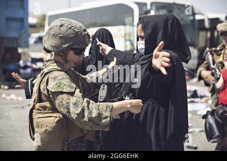 Kabul, Afghanistan. 28 agosto 2021. Una Marina degli Stati Uniti con la 24a unità di spedizione marina cerca una donna afghana mentre passa attraverso il Centro di controllo di evacuazione prima di evacuazione dall'Aeroporto Internazionale Hamid Karzai durante operazione Allees Refuge 28 agosto 2021 a Kabul, Afghanistan. Credit: Planetpix/Alamy Live News Foto Stock
