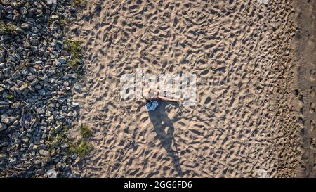 Donna che prende il sole sulla spiaggia di Arkutino Foto Stock
