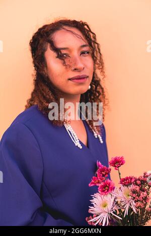 Ritratto di giovane donna con fiori in mano Foto Stock