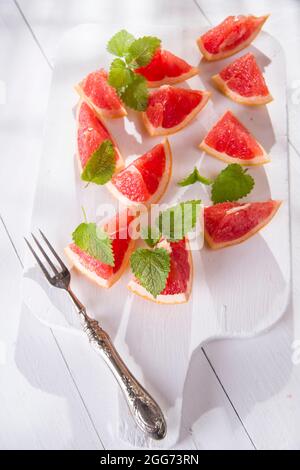 Presentazione sul rosso taglio Segmenti di pompelmi e di pomeli Foto Stock