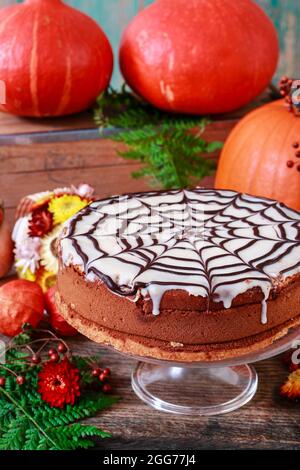 Halloween torta di fotoricettore del ragno di cioccolato e zucche intorno. Dessert da festa Foto Stock