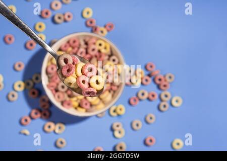 La colazione a base di cereali coloful offre delle costolette in un recipiente con cucchiaio Foto Stock