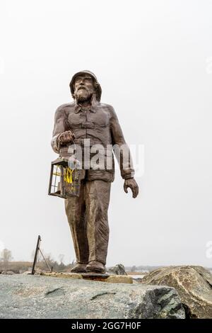 Point Pleasant, NJ - 23 ottobre 2020: Memoriale dei pescatori a Manasquan Inlet è una statua di bronzo di un pescatore che tiene una lanterna. Foto Stock